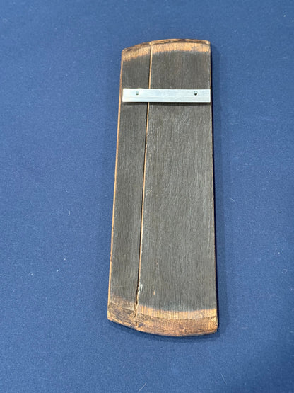 reverse side of 1/4 bourbon barrel lid with french cleat attached for hanging 