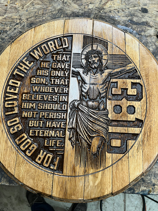 Bible verse "For God so loved the world..." on left half of bourbon barrel head and crucifix with 3:16 vertically on right half.